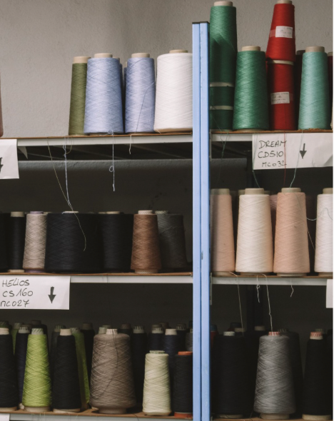 Geste précis sur une maille en cours de création, capturant l’essence du savoir‑faire Devernois : la beauté du travail artisanal, la noblesse des matières et l’élégance du mouvement